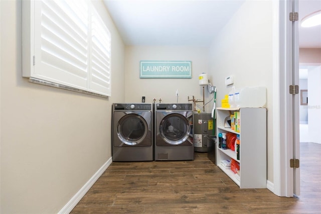 clothes washing area with electric water heater, dark wood-type flooring, and washer and clothes dryer