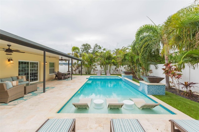 view of pool with ceiling fan, an outdoor living space, and a patio