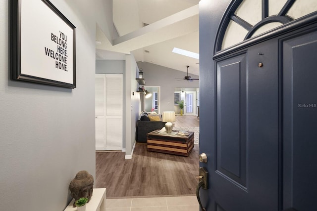 hallway with lofted ceiling and tile patterned floors