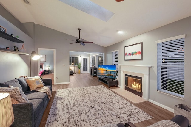 living room featuring ceiling fan, light wood-type flooring, and lofted ceiling