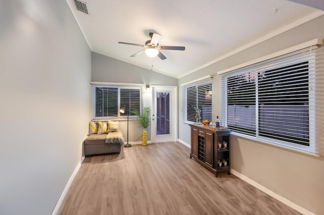 interior space featuring lofted ceiling, hardwood / wood-style flooring, ceiling fan, and ornamental molding