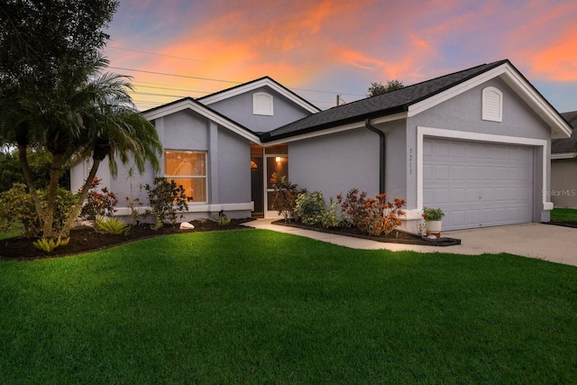 single story home featuring a lawn and a garage