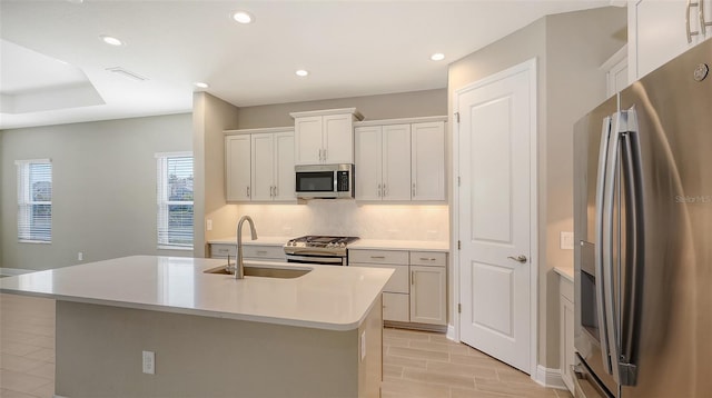 kitchen with sink, white cabinetry, an island with sink, and appliances with stainless steel finishes