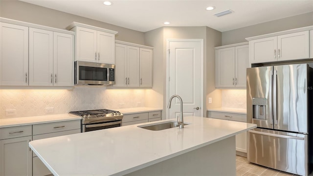 kitchen with sink, an island with sink, and appliances with stainless steel finishes