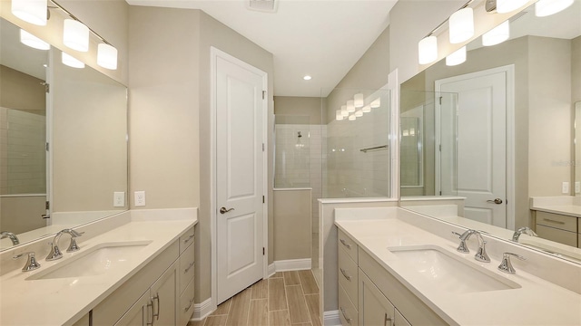 bathroom featuring a tile shower and vanity