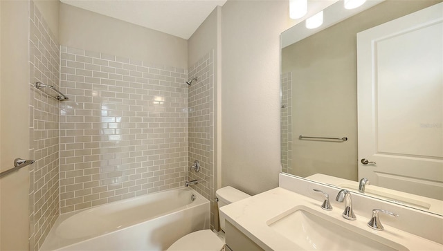 full bathroom featuring toilet, tiled shower / bath, and vanity