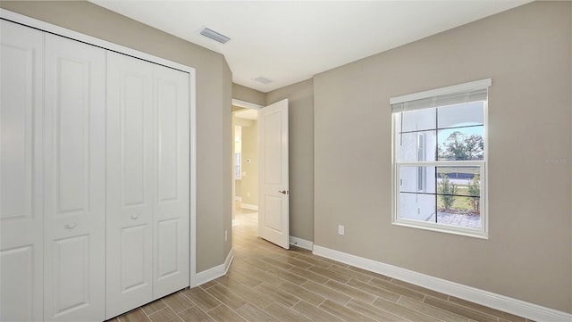 unfurnished bedroom with light hardwood / wood-style flooring and a closet