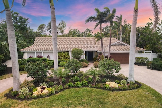 view of front of property with a garage and a lawn