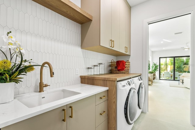 laundry area featuring ceiling fan, cabinets, separate washer and dryer, and sink