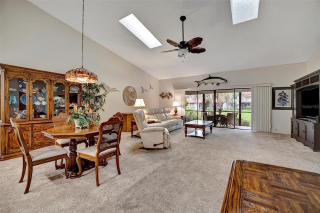 carpeted living room featuring ceiling fan, high vaulted ceiling, and a skylight