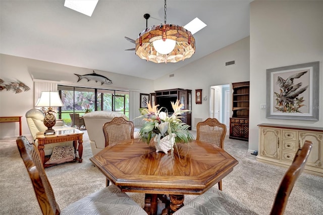 carpeted dining space with high vaulted ceiling and a skylight