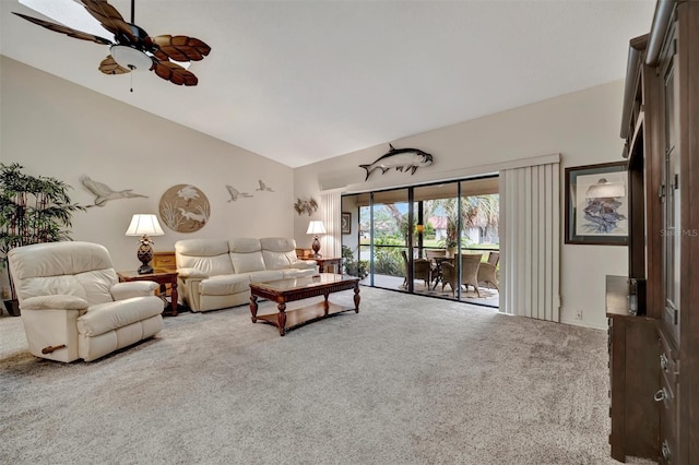 carpeted living room with ceiling fan and vaulted ceiling