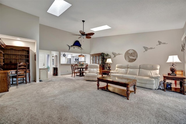 carpeted living room featuring a skylight and ceiling fan