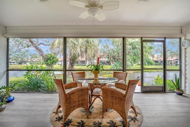 sunroom with a water view and ceiling fan