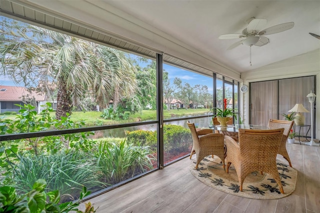 sunroom featuring ceiling fan, lofted ceiling, and a water view