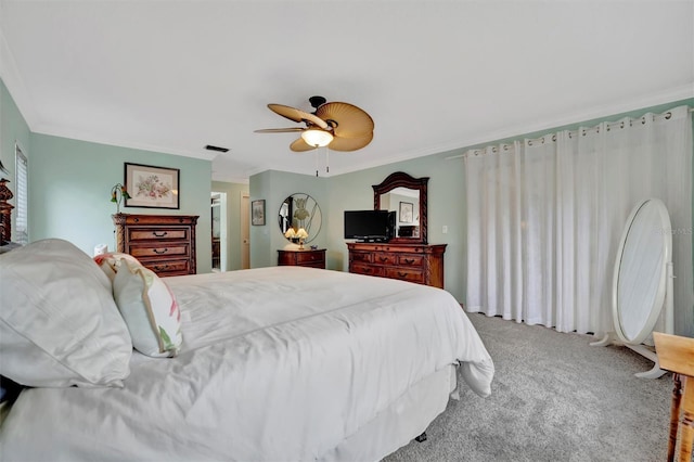 carpeted bedroom with ceiling fan and ornamental molding