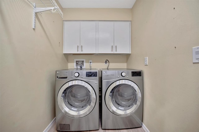 clothes washing area featuring cabinets and independent washer and dryer