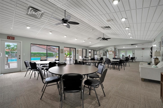 carpeted dining room with vaulted ceiling and ceiling fan