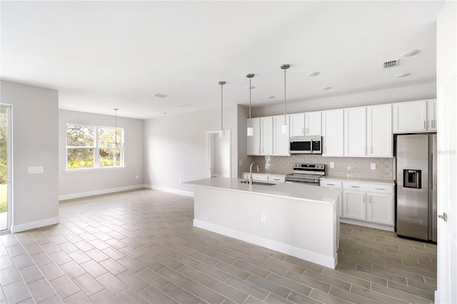 kitchen with stainless steel appliances, hanging light fixtures, and white cabinets