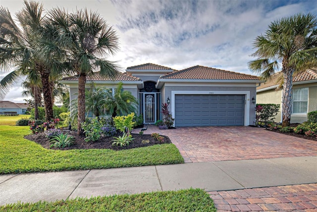 mediterranean / spanish house featuring a garage and a front yard