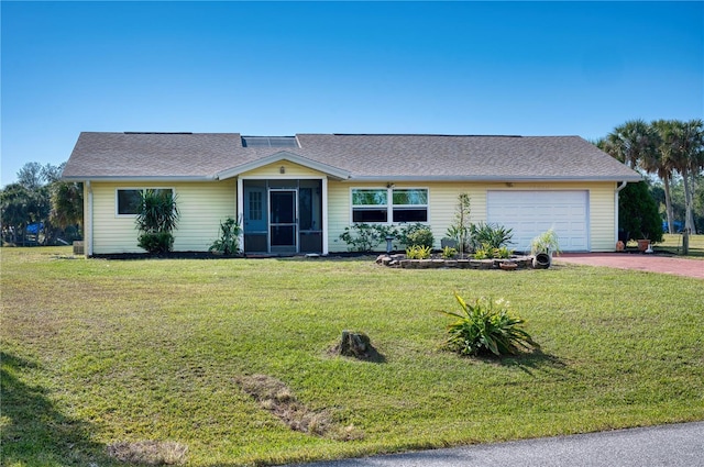 ranch-style house featuring a garage and a front lawn