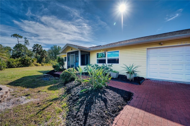 single story home featuring a porch, a garage, and a front yard