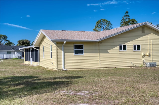 view of side of property with cooling unit, a yard, and a sunroom