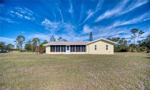 rear view of house with a sunroom and a yard