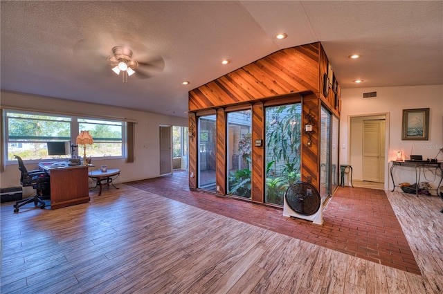 interior space featuring hardwood / wood-style floors, vaulted ceiling, and a textured ceiling