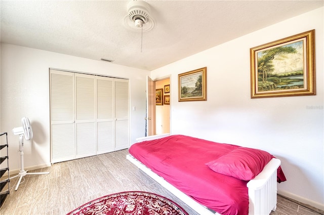 bedroom with a closet, wood-type flooring, and a textured ceiling