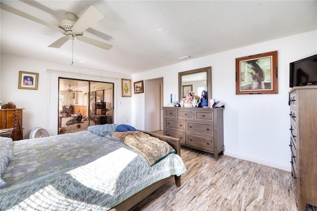 bedroom featuring ceiling fan, light hardwood / wood-style floors, and a textured ceiling