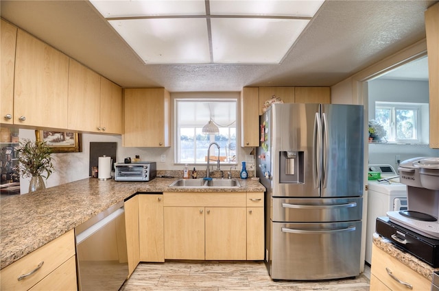 kitchen featuring sink, washer / dryer, light brown cabinets, and appliances with stainless steel finishes