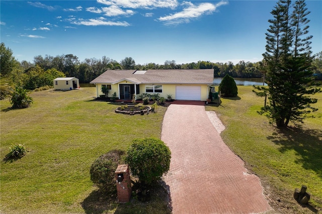 ranch-style house featuring a garage, a water view, and a front lawn