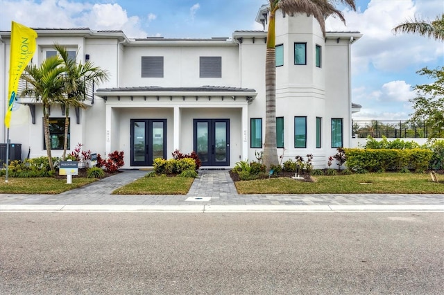 mediterranean / spanish-style home with central air condition unit and french doors