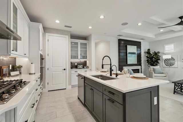 kitchen with white cabinets, wall chimney exhaust hood, stainless steel appliances, sink, and gray cabinets