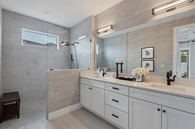 bathroom featuring vanity, tile patterned flooring, a wealth of natural light, and a tile shower