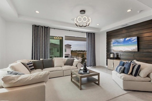 living room featuring a tray ceiling and wooden walls