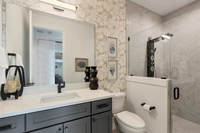 bathroom featuring toilet, a shower with shower door, and vanity