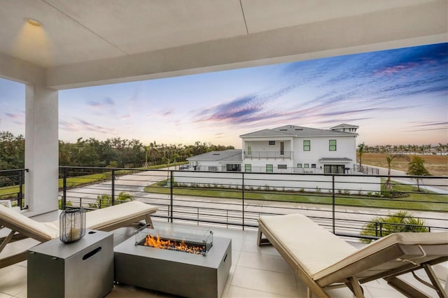 patio terrace at dusk with a balcony and a fire pit