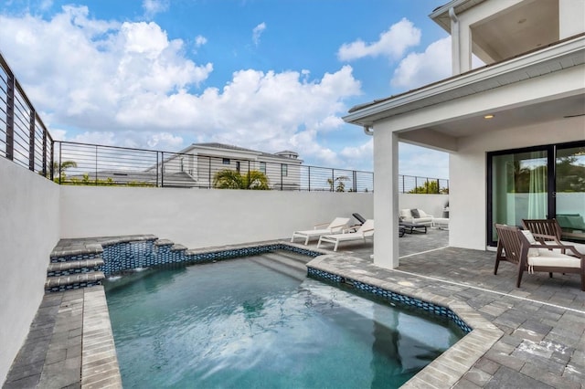 view of swimming pool featuring pool water feature and a patio