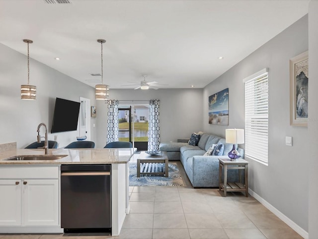 kitchen with ceiling fan, sink, white cabinetry, hanging light fixtures, and light stone counters