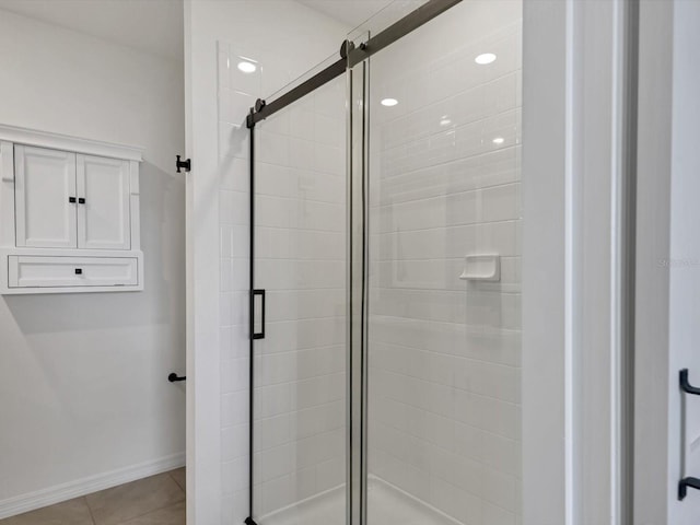 bathroom featuring a shower with shower door and tile patterned flooring