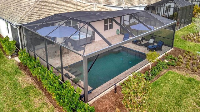 back of house featuring a patio area, a yard, and glass enclosure