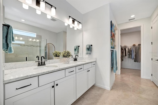 bathroom with an enclosed shower, vanity, and tile patterned flooring