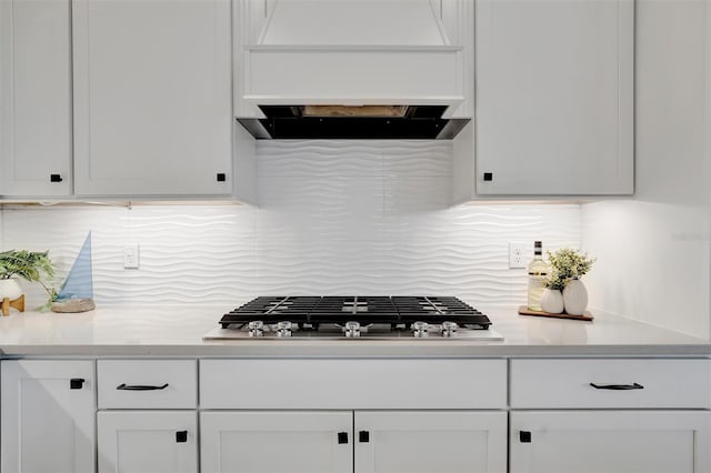 kitchen with custom exhaust hood, white cabinets, and stainless steel gas cooktop