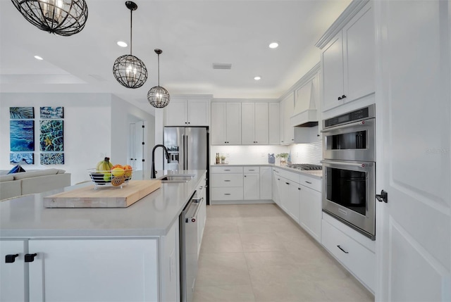 kitchen featuring a chandelier, a kitchen island with sink, white cabinetry, and appliances with stainless steel finishes