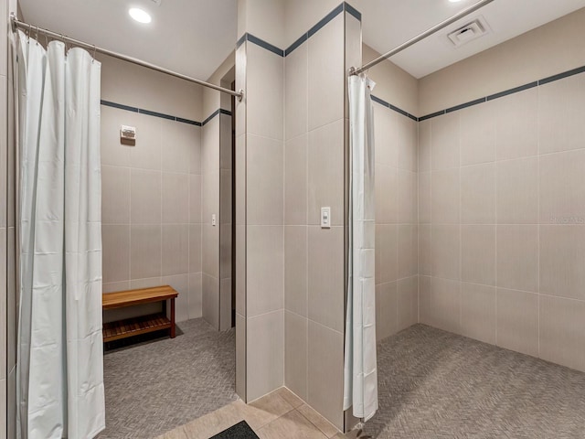 bathroom with curtained shower and tile walls