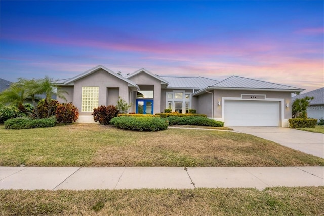 single story home with a lawn and a garage