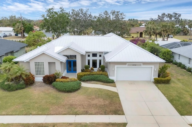 view of front facade featuring a front lawn, a garage, and french doors