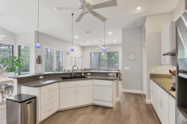 kitchen featuring hanging light fixtures, white cabinets, dishwasher, and sink